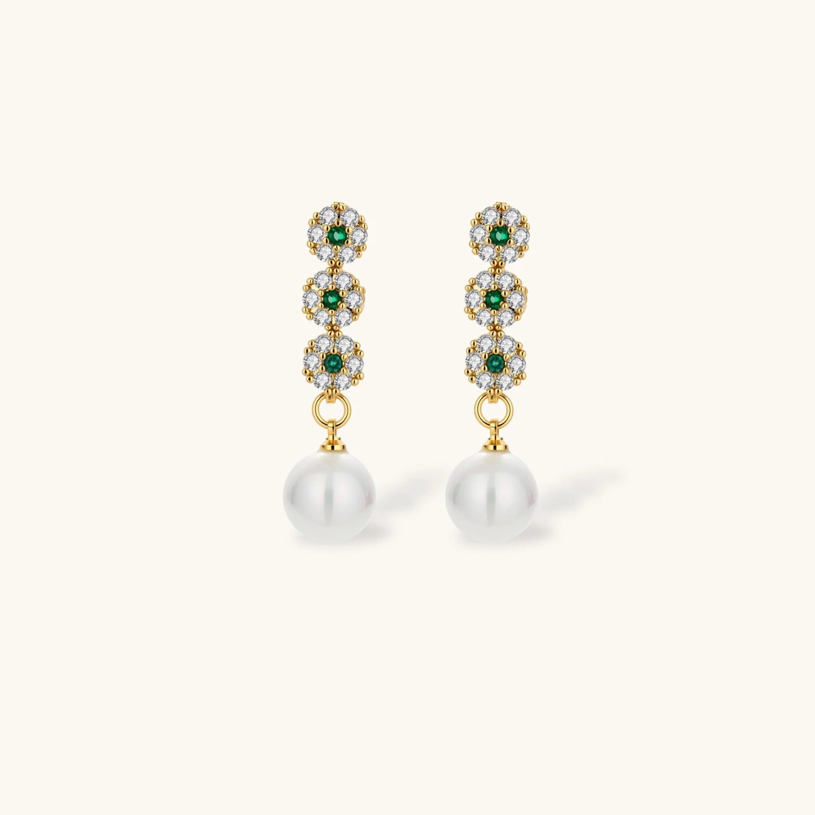 Gold-plated jewelry set with green cubic zirconia floral motifs, featuring matching necklace and pearl drop earrings
