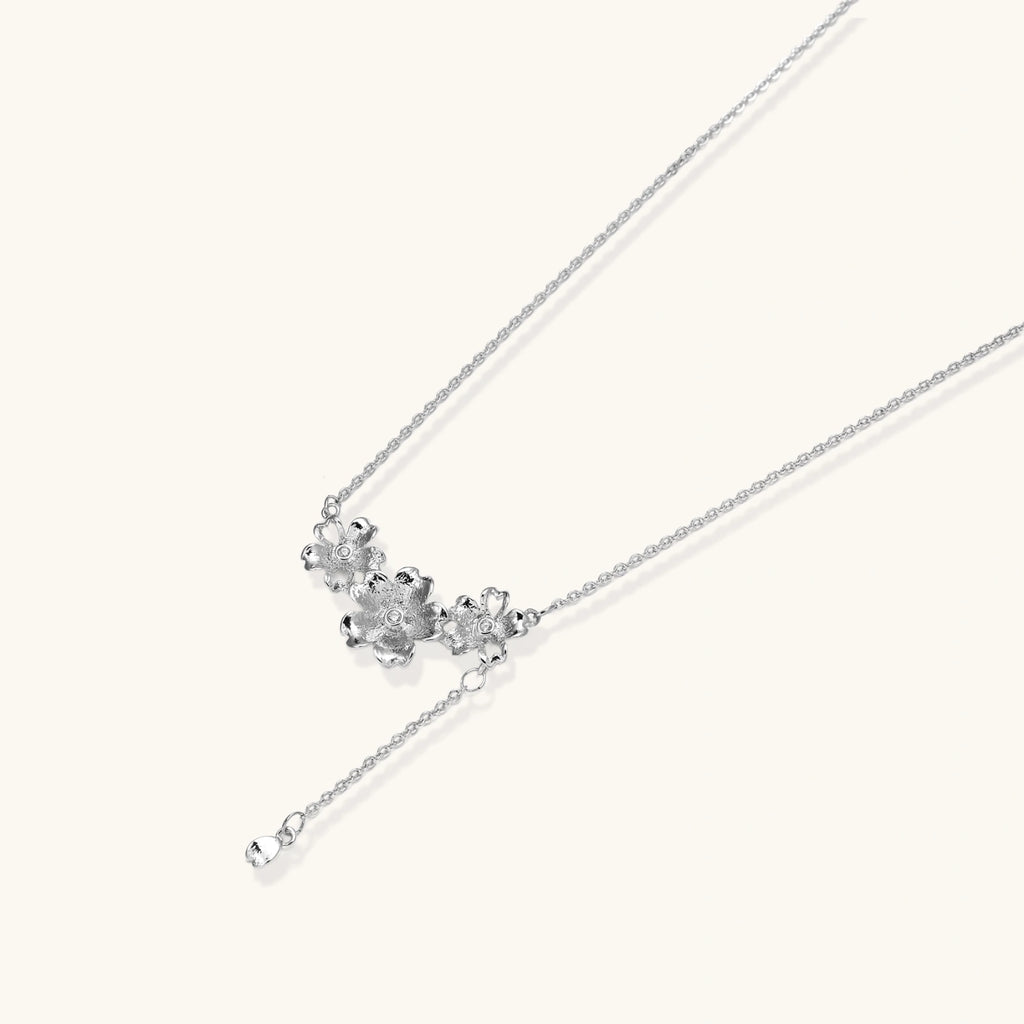 White gold plated Y-shaped necklace with three dimensional flower charms and adjustable drop pendant